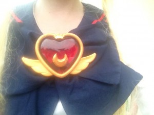 A chest shot of Usagi's crisis brooch and school uniform