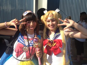 Two girls dressed as sailor moon pose for the camera. one is holding the moon scepter.