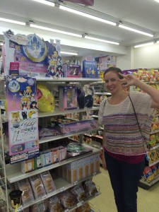 A young white woman poses infront of a Sailor Moon ichiban kuji display