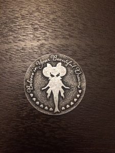 a silver coin with the silhouette of chibimoon