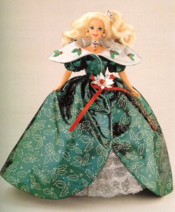 A blonde barbie wears a long beauitufl green dress with a holly berry motif