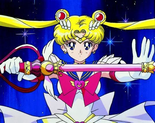 Super Sailor Moon faces the camera with the moon kaleidoscope held out horizontally.