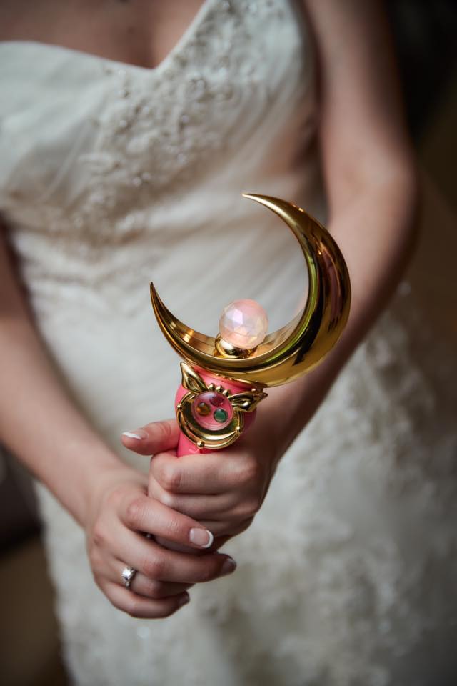 a bride holding a proplica moon stick