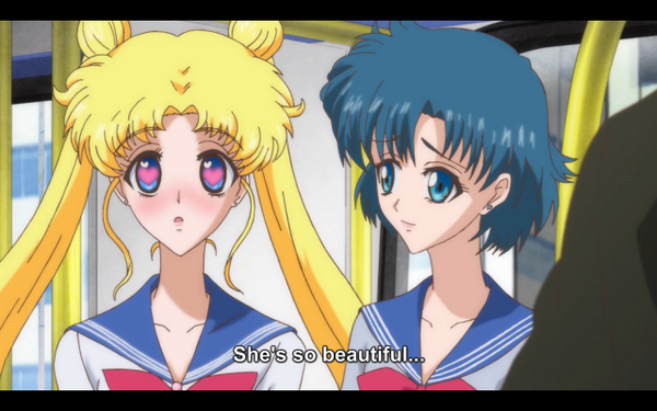 A screenshot from Sailor Moon Crystal with Usagi staring at Rei with hearts in her eyes. The subtitle reads "She's so beautiful..."