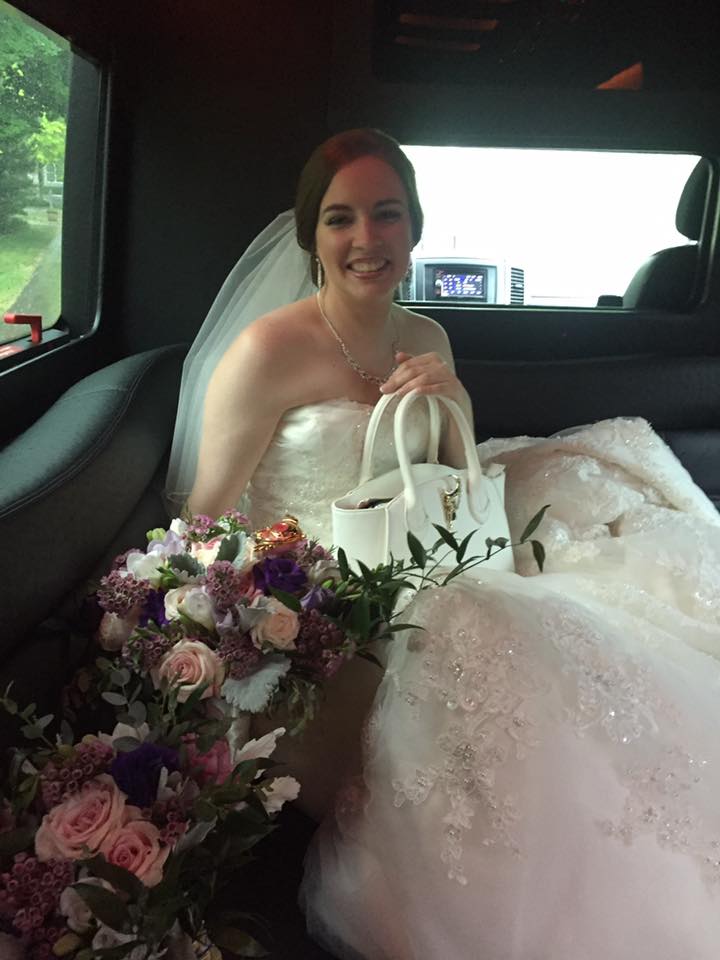 a bride sits in car with a white sailor moon bag